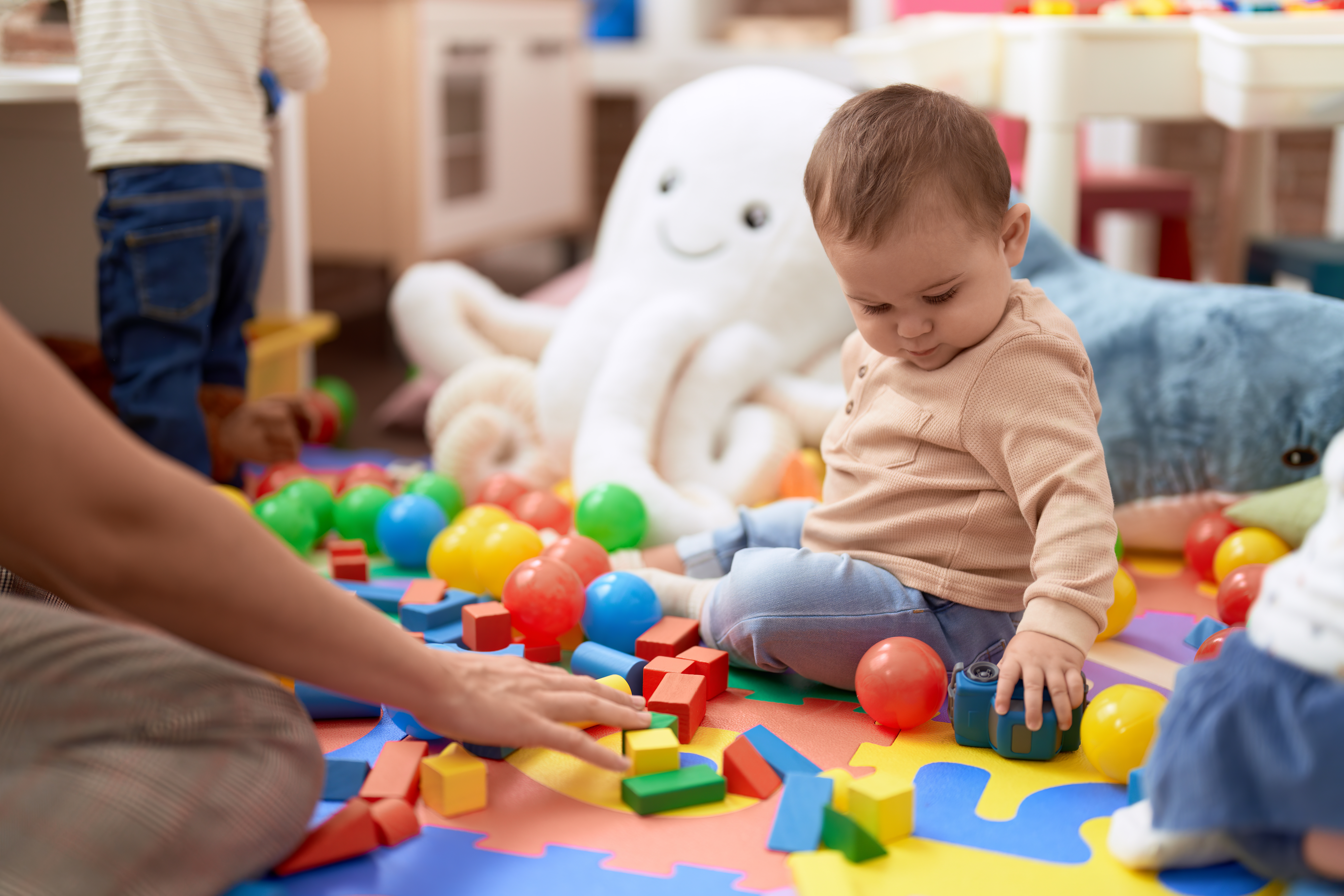 Young child on play mat with toys